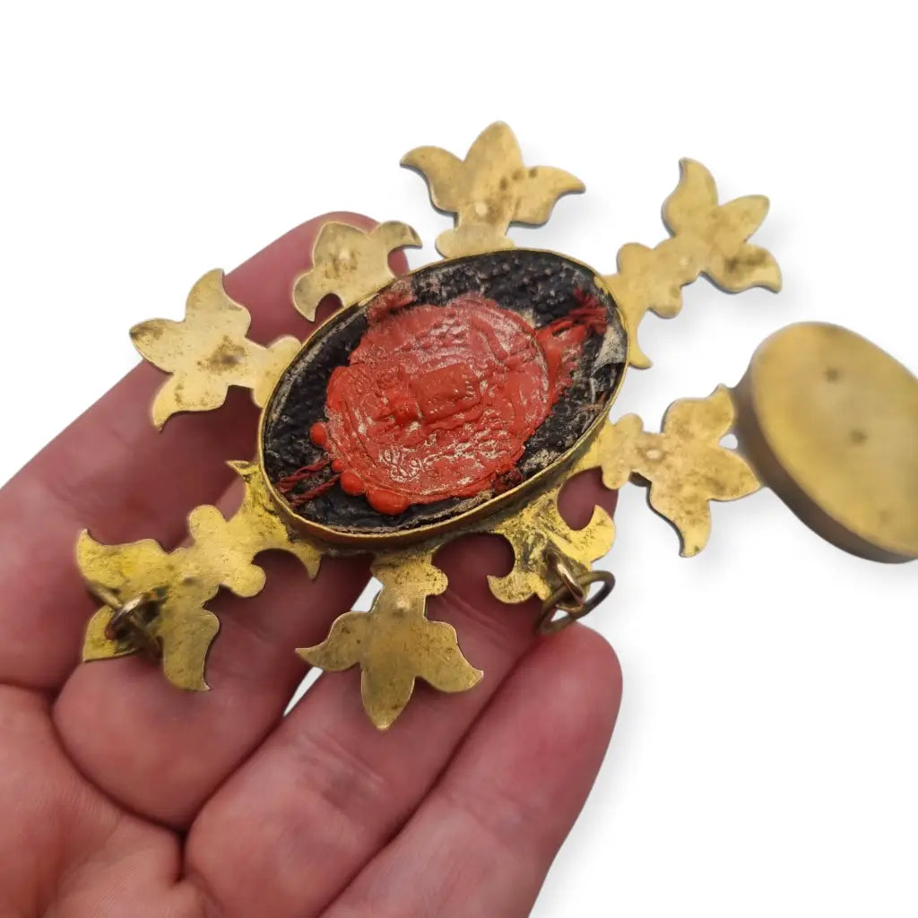 Relicario antiguo colgante con cinco reliquias selladas en metal dorado y gemas