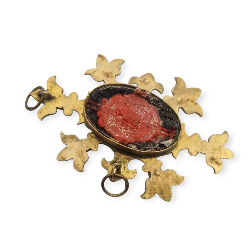 Relicario antiguo colgante con cinco reliquias selladas en metal dorado y gemas