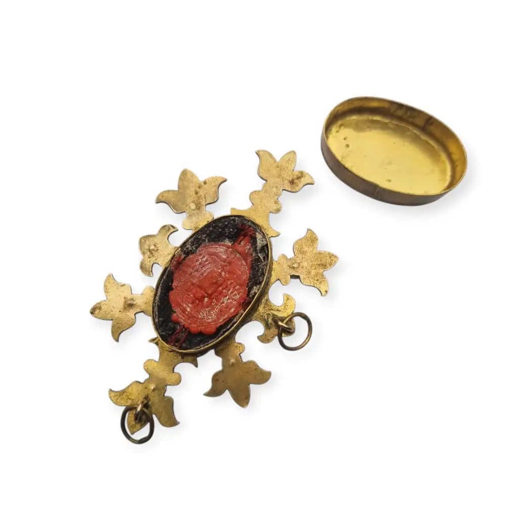 Relicario antiguo colgante con cinco reliquias selladas en metal dorado y gemas