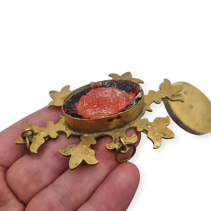 Relicario antiguo colgante con cinco reliquias selladas en metal dorado y gemas