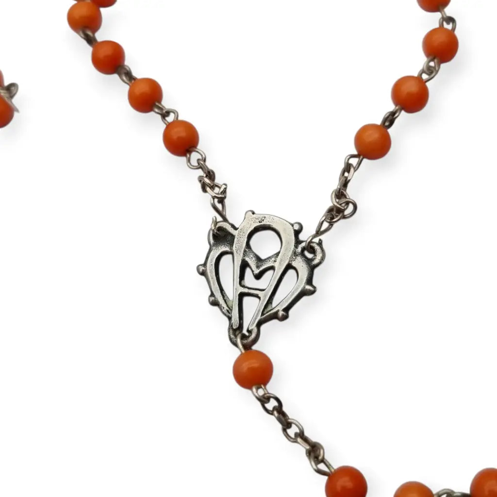 Rosario en plata con cuentas de coral rojo cruz estilizada artesanal estilo